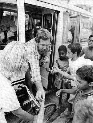 Ship's captain Skip Lembright hands candy to the children who quickly gather when the crew's tourist van stops in downtown Havana. The van, one of the few vehicles on the island, draws a crowd wherever it goes.