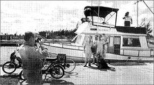 Members of Aduana, the Cuban customs agency, pose with the ship's captain after conducting a cursory inspection of the Newfie Bullet with their drug-sniffing German Shepherd, Elf.